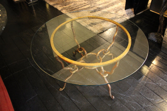 Tavolino modernariato anni '40 con piano in vetro e base scultorea in ferro battuto finitura oro.