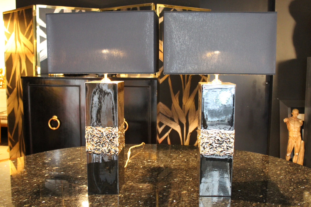 Coppia di lampade da tavolo modernariato anni '70 in ceramica nera lucida con fascia centrale in rilievo dorato e paralumi neri.