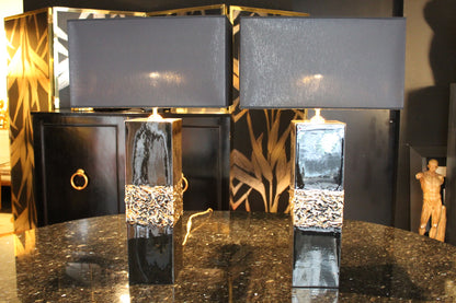 Coppia di lampade da tavolo modernariato anni '70 in ceramica nera lucida con fascia centrale in rilievo dorato e paralumi neri.