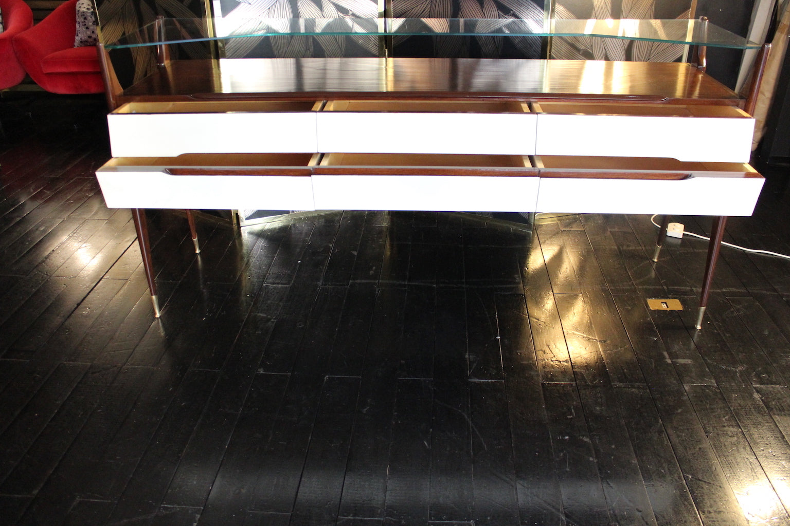 Console modernariato anni '50 in palissandro con cassetti bianchi, gambe affusolate e ripiano in vetro.

