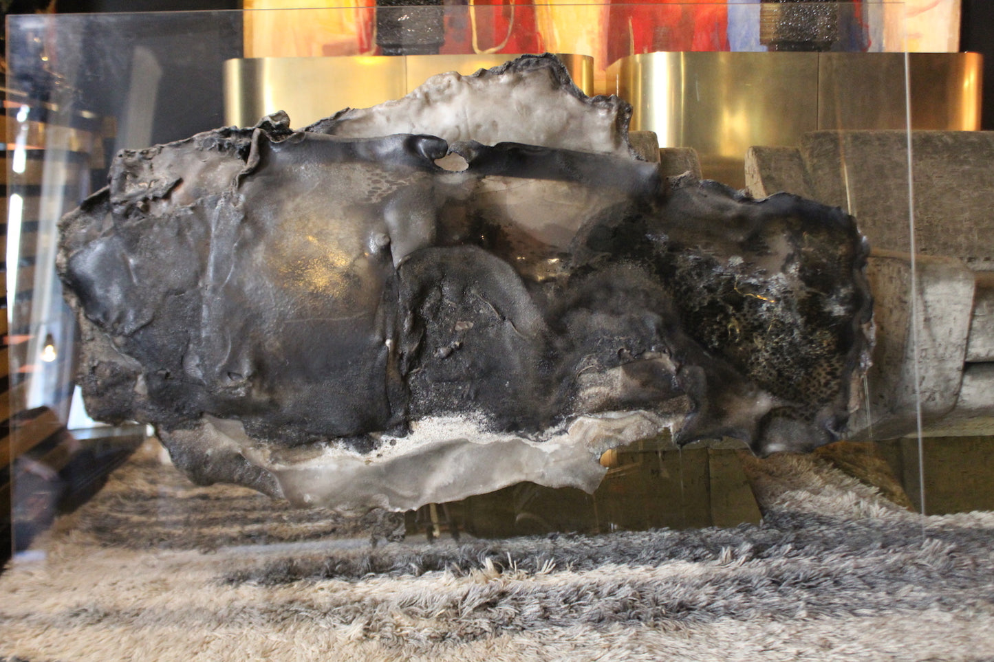 Pannello scultoreo astratto di L. Sonzini in resina lavorata, con finitura organica scura e bordi chiari.